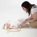 Parent changing baby on toddlekind baby portable changing clutch mini maven tofu opened flat for diapering.