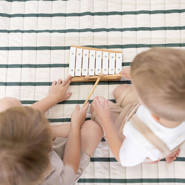 Overhead view of children playing xylophone on striped cushioned mat – toddlekind portable water resistant wander grande play mat forest for interactive play
