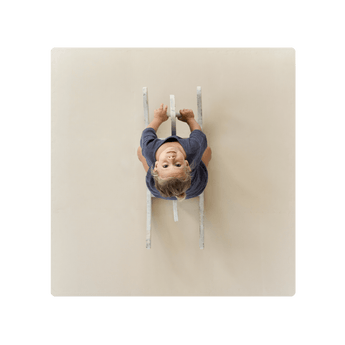 Overhead view of child on ride-on toy on toddlekind baby toddler foam modern puzzle play mat classic clay. Alt Img