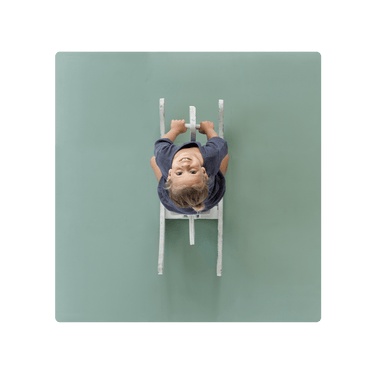 Overhead view of smiling toddler on ride-on toy on toddlekind baby toddler foam modern puzzle play mat classic moss. Alt Img