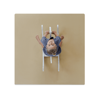 Overhead view of child on ride-on toy on toddlekind baby toddler foam modern puzzle play mat classic sandstone. Alt Img