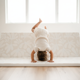 Baby practicing movement near window on toddlekind baby toddler foldable foam cushioned tumble play mat willow ava.
