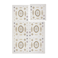 Interlocking foam tiles with lifted corner showing puzzle edges of the toddlekind baby toddler foam modern designer puzzle play mat haven amira golden clay.