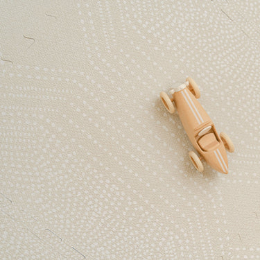 Overhead view of assembled toddlekind baby toddler foam modern designer puzzle play mat haven deco ecru with visible seams and wooden toy.