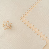 Wooden toy car placed on the toddlekind baby toddler foam modern designer puzzle play mat haven deco ecru showing subtle pattern detail.