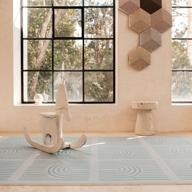 Minimal interior scene with rocking toy placed on the toddlekind baby toddler foam modern designer puzzle play mat haven linear mineral