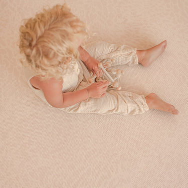 child sitting on toddlekind haven foam puzzle play mat in wild dune