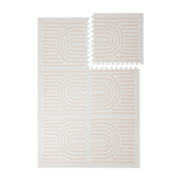 Interlocking foam tiles arranged in a grid with one corner lifted showing edges of the toddlekind baby toddler foam modern designer puzzle play mat haven linear linen.