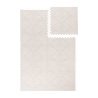 Interlocking tiles arranged in a grid with one piece lifted showing the toddlekind baby toddler foam modern designer puzzle play mat haven tulum bone.