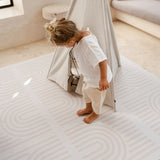 Baby toddler standing near a play teepee exploring the toddlekind baby toddler foam modern designer puzzle play mat haven linear linen.