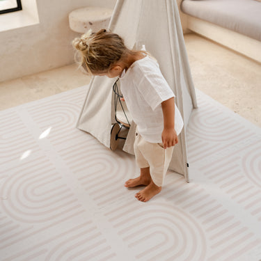 Baby toddler standing near a play teepee exploring the toddlekind baby toddler foam modern designer puzzle play mat haven linear linen.