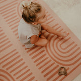 Baby toddler sitting on the patterned surface with a toy on the toddlekind baby toddler foam modern designer puzzle play mat haven linear camel.