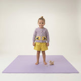 Toddler standing on play mat with pull toy on toddlekind baby toddler foam modern puzzle play mat classic lilac.