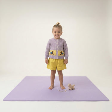 Toddler standing on play mat with pull toy on toddlekind baby toddler foam modern puzzle play mat classic lilac.