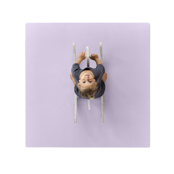 Overhead view of toddler on ride-on toy centered on toddlekind baby toddler foam modern puzzle play mat classic lilac. Alt Img