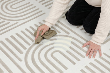 Close-up of the easy to clean Toddlekind Linear Putty foam playmat being wiped clean