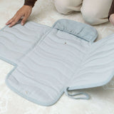 Close-up of toddlekind baby portable changing clutch mini maven slate opened flat showing quilted interior and compartments.