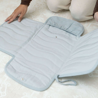 Close-up of toddlekind baby portable changing clutch mini maven slate opened flat showing quilted interior and compartments.