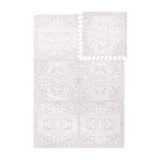 Interlocking foam tiles with one tile lifted to show puzzle edges of the toddlekind baby toddler foam modern designer puzzle play mat haven parisa millet.