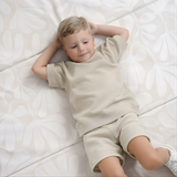 Child relaxing on cushioned surface of toddlekind baby toddler foldable foam cushioned tumble play mat willow ava.
