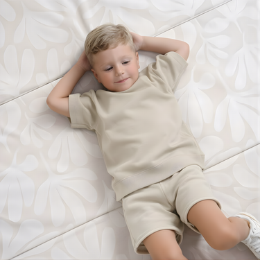 Child relaxing on cushioned surface of toddlekind baby toddler foldable foam cushioned tumble play mat willow ava.