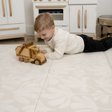 Toddler playing with wooden truck on toddlekind baby toddler foldable foam cushioned tumble play mat willow ava.
