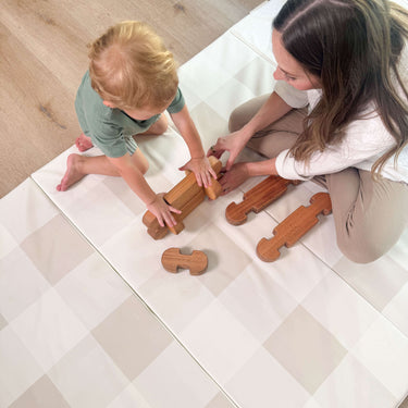 Parent and toddler playing with wooden toys on toddlekind baby toddler foldable foam cushioned tumble play mat arden dove.