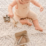 Close-up of baby playing with sand toys on patterned mat – toddlekind portable water resistant wander classic play mat ocean stone for sensory exploration