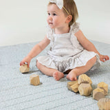 Baby sitting with wooden blocks on soft floral mat – toddlekind portable water resistant wander grande play mat for comfortable play space