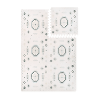 Interlocking foam tiles with one tile lifted to show puzzle edges of the toddlekind baby toddler foam modern designer puzzle play mat haven amira seagrass.