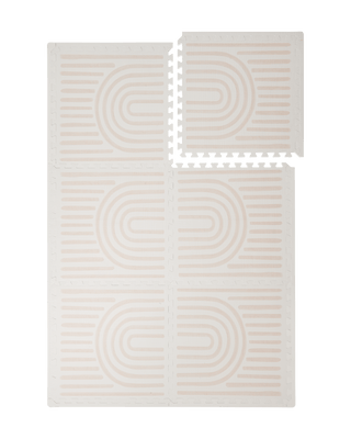 Interlocking foam tiles arranged in a grid with one corner lifted showing edges of the toddlekind baby toddler foam modern designer puzzle play mat haven linear linen.

