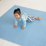 Toddler crawling and playing on toddlekind baby toddler foam modern puzzle play mat classic slate with soft surface.
