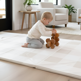 Baby stacking wooden toys while kneeling on toddlekind baby toddler foldable foam cushioned tumble play mat arden dove.
