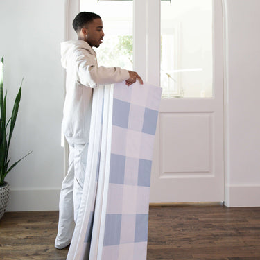 Adult carrying folded toddlekind baby toddler foldable foam cushioned tumble play mat arden tide for easy storage.
