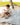 Baby sitting on a soft sage green mat in a sandbox, playing with sand and a small bowl, showcasing the toddlekind portable water resistant wander classic play mat botanical sage in an outdoor setting.
