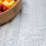 Close-up of floral pattern play mat with fruit bowl – toddlekind portable water resistant wander grande play mat in soft blue design
